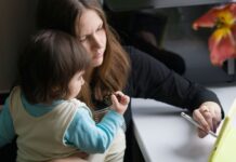 Mama z dzieckiem korzystają z tabletu w domowym zaciszu