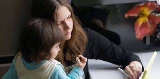 Mama z dzieckiem korzystają z tabletu w domowym zaciszu