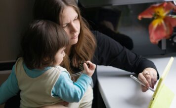 Mama z dzieckiem korzystają z tabletu w domowym zaciszu