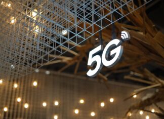 Edge computing i 5G: duet, który zmieni oblicze internetu rzeczy i automatyzacji Podświetlony znak 5G na tle nowoczesnego, geometrycznego sufitu