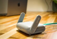 Najnowsze routery Wi‑Fi 7 w praktyce: czy opłaca się wymieniać domową sieć teraz Router Wi‑Fi 6 z antenami na drewnianym biurku w nowoczesnym domu