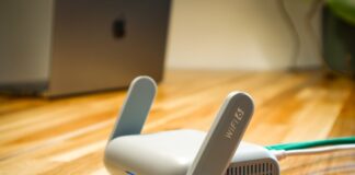 Router Wi‑Fi 6 z antenami na drewnianym biurku w nowoczesnym domu