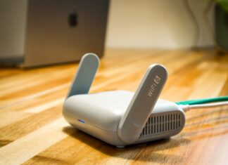 Najnowsze routery Wi‑Fi 7 w praktyce: czy opłaca się wymieniać domową sieć teraz Router Wi‑Fi 6 z antenami na drewnianym biurku w nowoczesnym domu