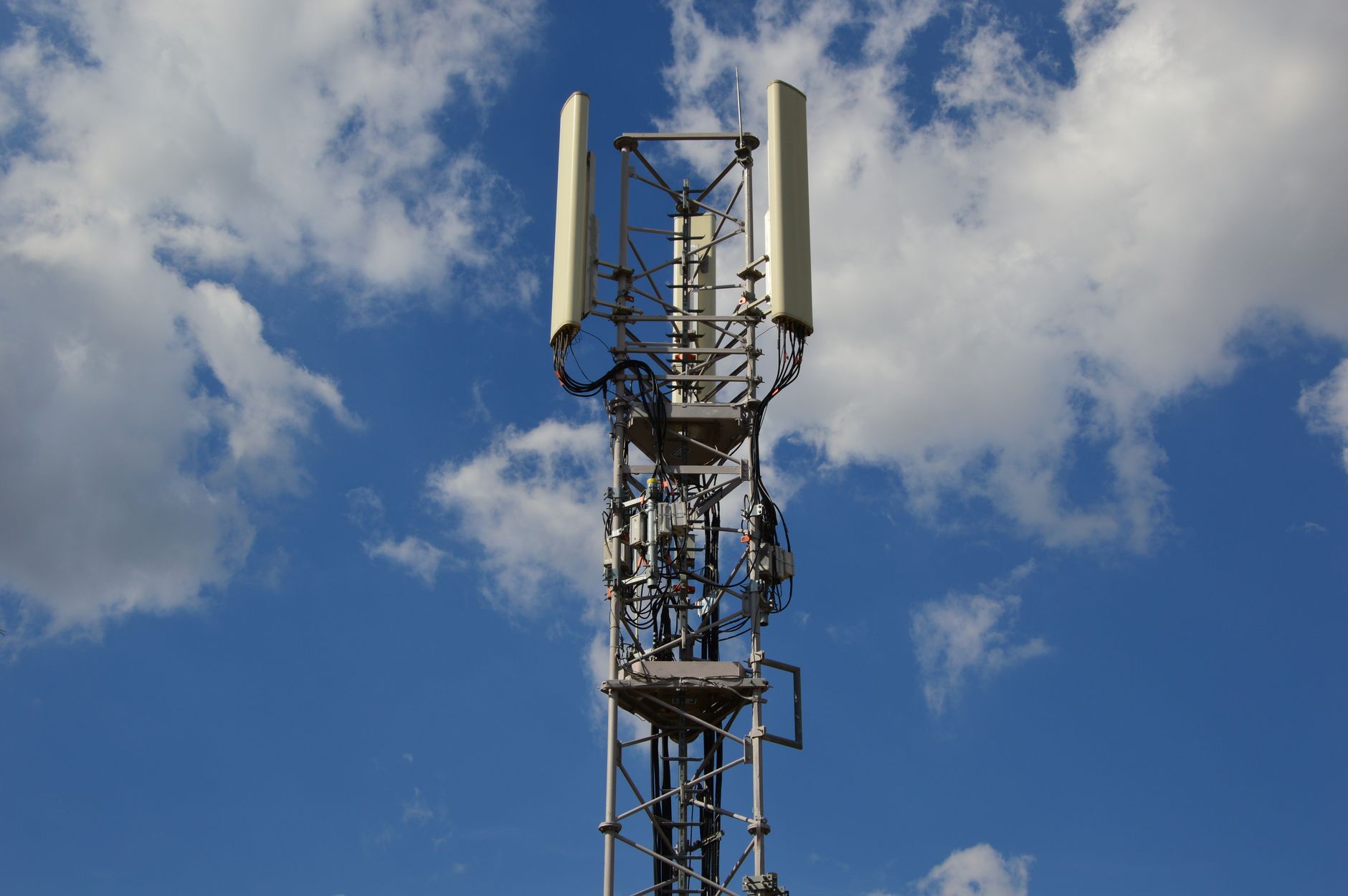 Wysoka wieża 5G na tle intensywnie niebieskiego nieba