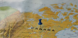 Żółta mapa Kanady z niebieską pinezką wskazującą miejsce путеше